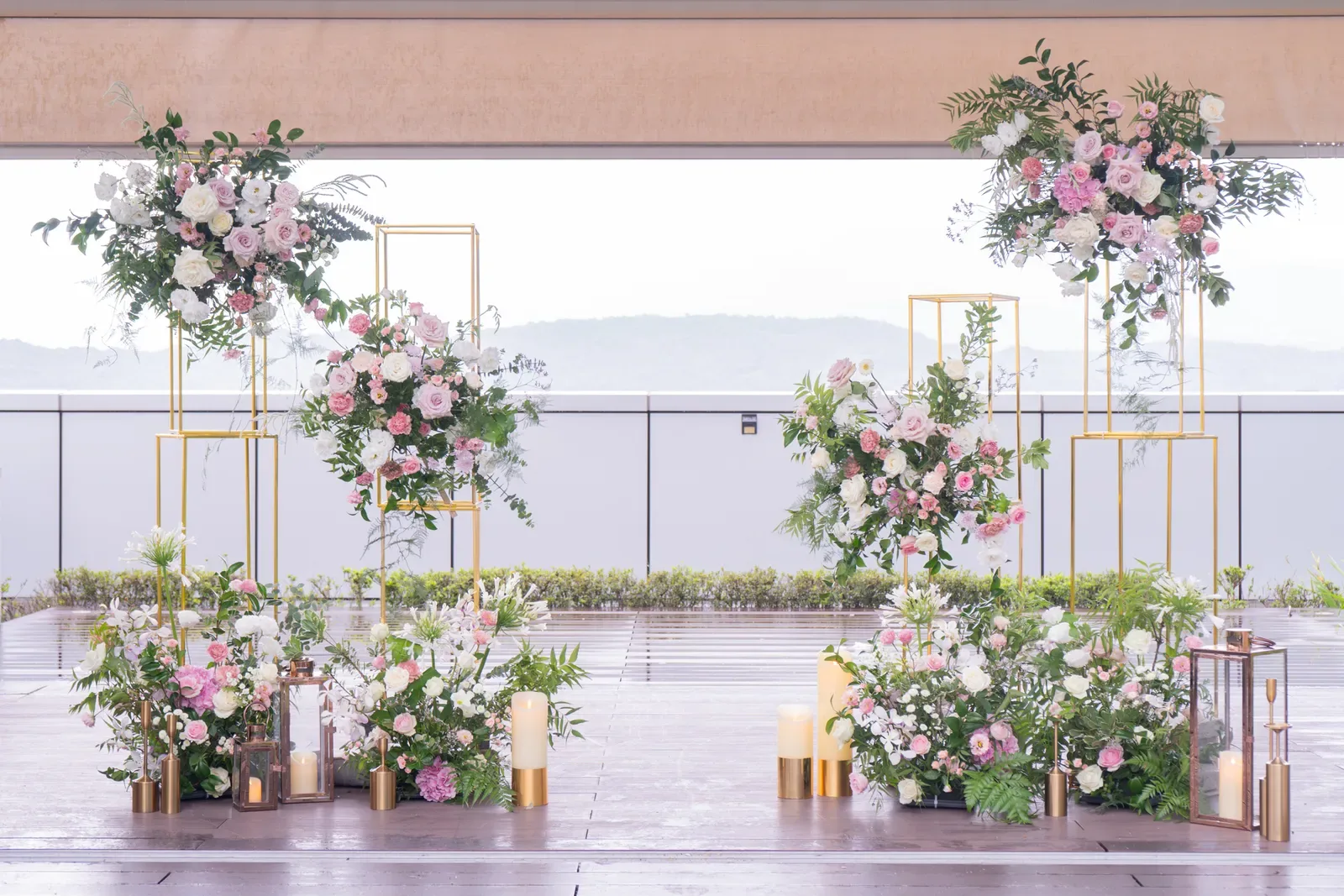 空中花園露台婚禮佈置側景，粉白玫瑰花柱與落地花叢