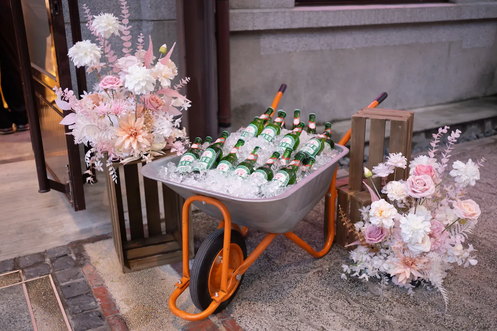 瓶蓋工廠迎賓佈置,工業手推車冰台啤配粉色花藝的反差開場