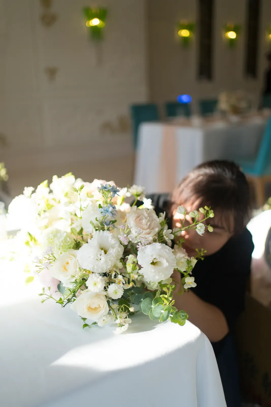 文華東方婚禮現場花藝師手捧白色鮮花,庭園證婚前做最後調整