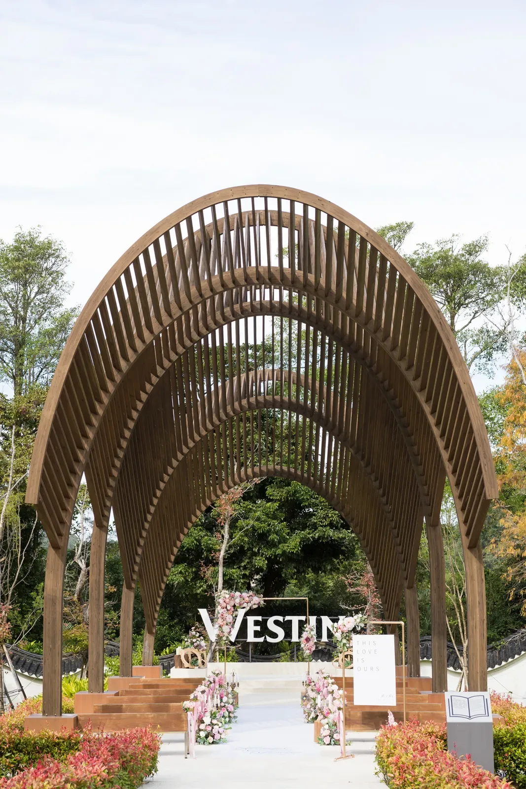 大溪威斯汀曲木拱廊透視,木廊盡頭為粉花拱門與 WESTIN 白字