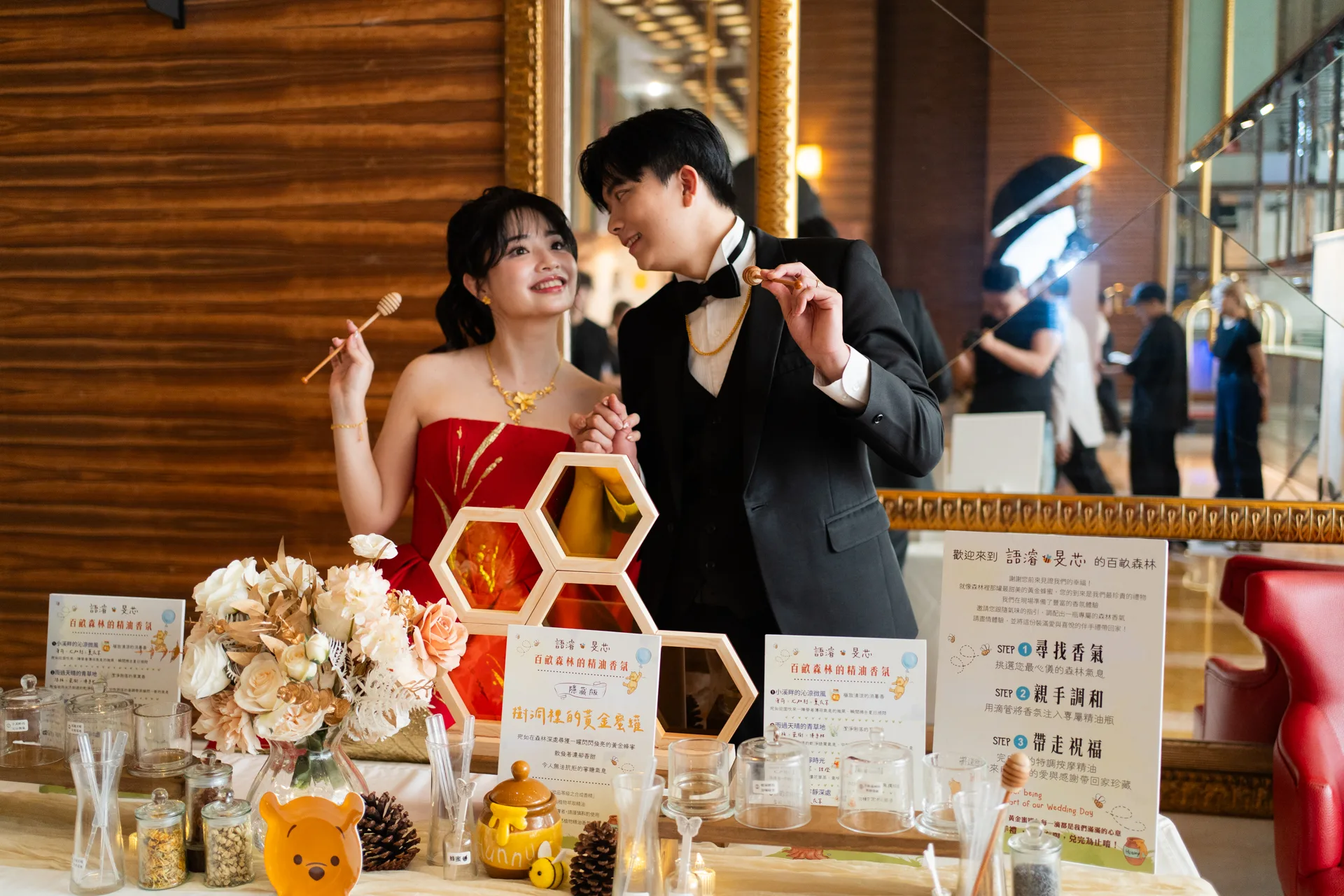 新人各持一支蜂蜜攪拌棒相視而笑並牽著手,婚禮精油調香活動