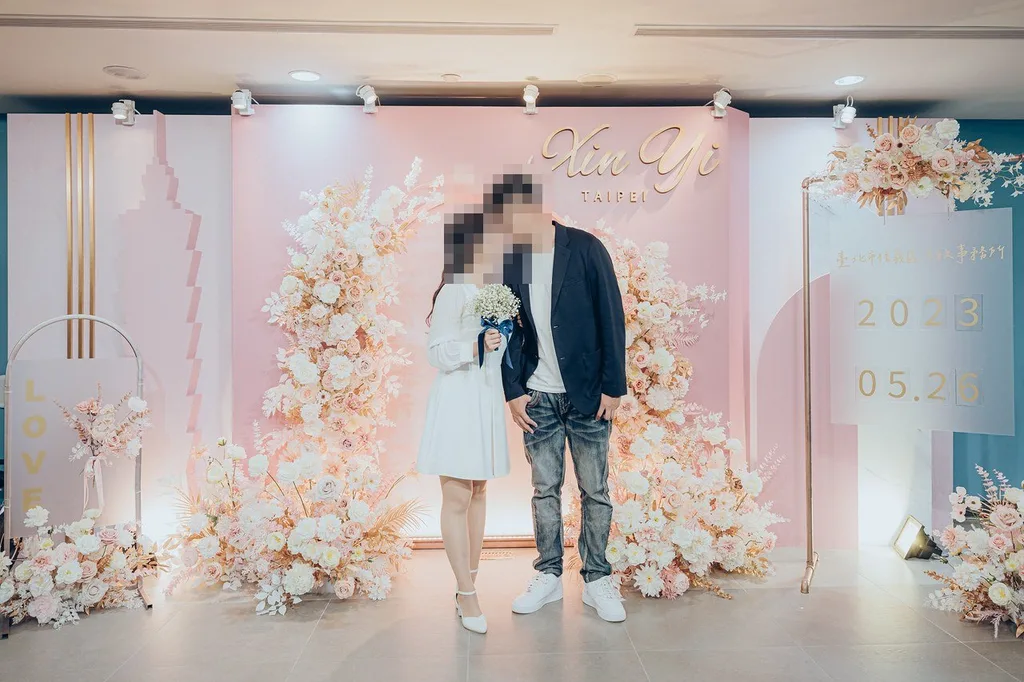 職業婚攝作品,信義背板前的新人合照,臉部已馬賽克。婚攝「小刀」(伙伴婚攝),2023.05.26,photos.smugmug.com