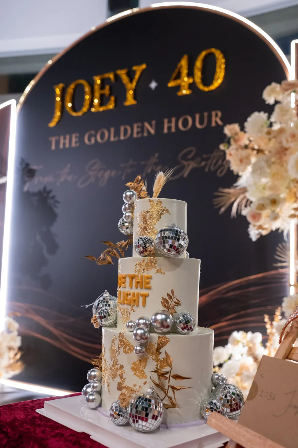JOEY 40 生日蛋糕，白色三層蛋糕貼金箔，銀色鏡面球與乾燥花，蛋糕上寫著 BE THE LIGHT