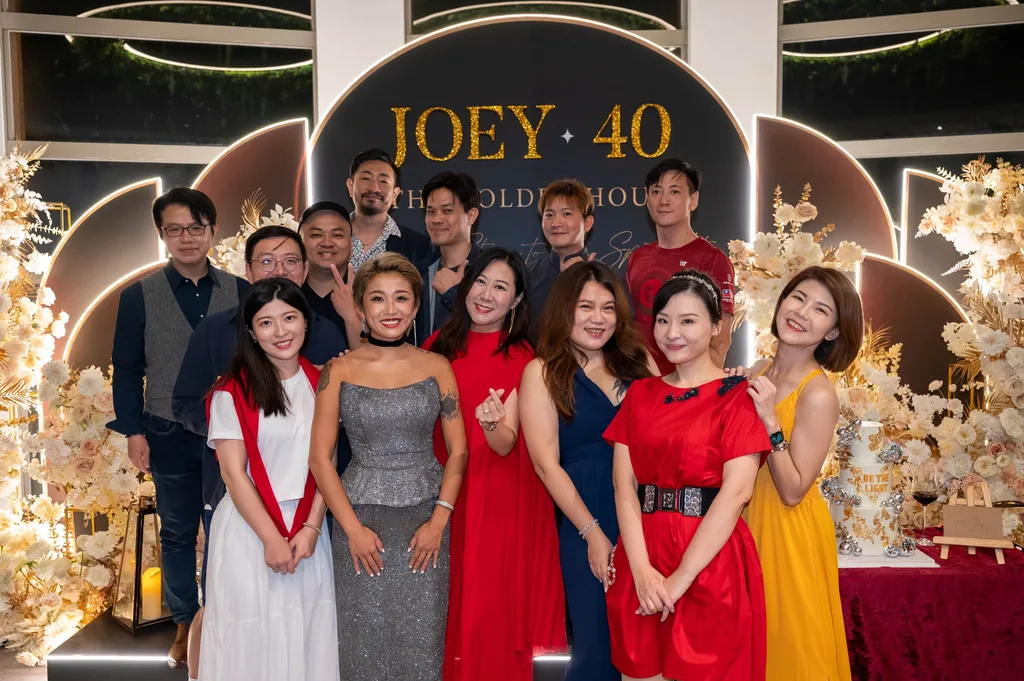 Joey 與朋友們在 JOEY 40 背板前合照