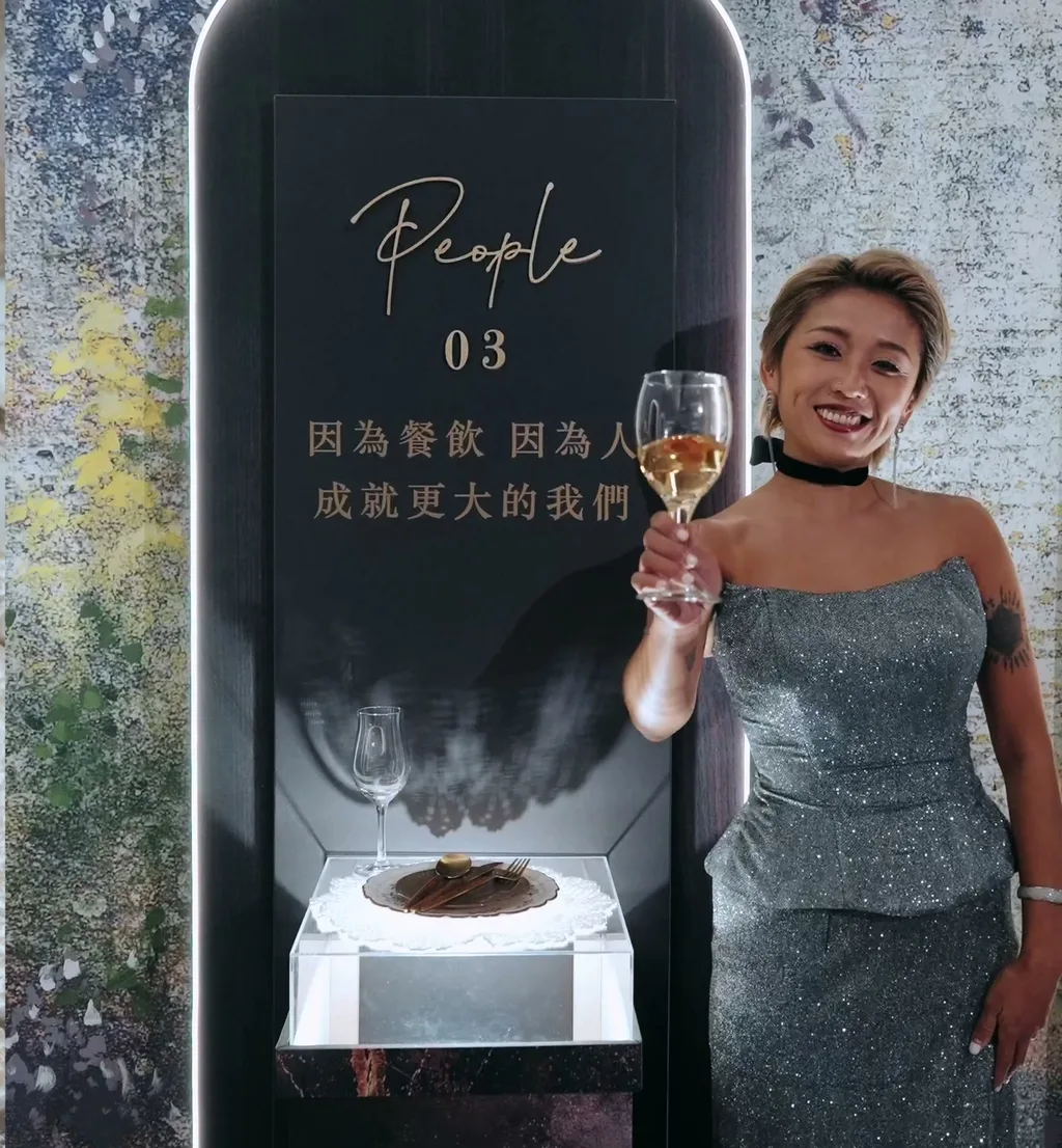 壽星在光的軌跡 03 People 看台旁舉杯,看台上寫著「因為餐飲 因為人 成就更大的我們」,台大明達館 MD 創作料理