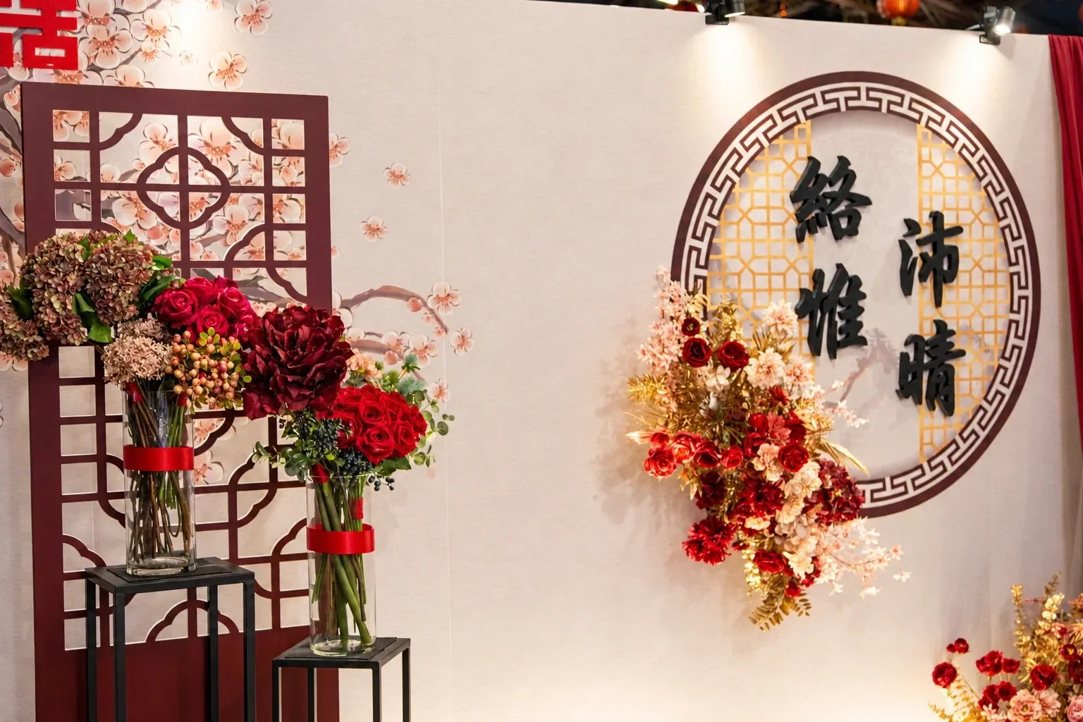 小軒窗圓形回紋框與金色窗花特寫,旁邊是紅色與蜜桃色花藝