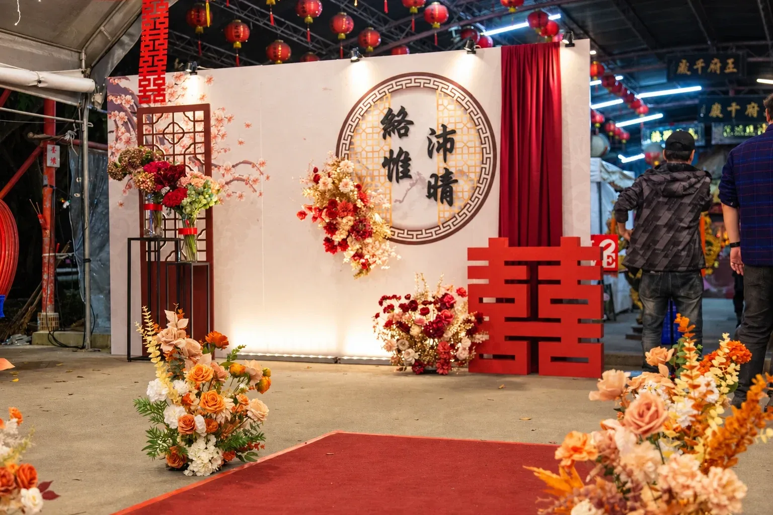 從紅毯低角度看小軒窗背板,兩側地面是橘色與米白色花藝