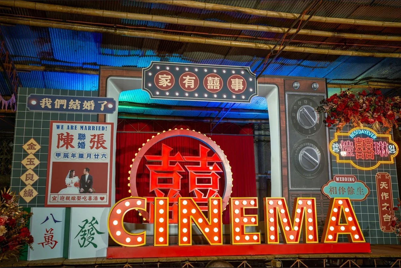 復古電影院主題婚禮背板，有雙囍字、紅黃燈飾與新人照片，喜氣洋洋。