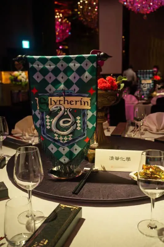 婚宴桌上，Slytherin旗幟、酒杯與紅色花束，營造神秘溫暖的婚禮氛圍。