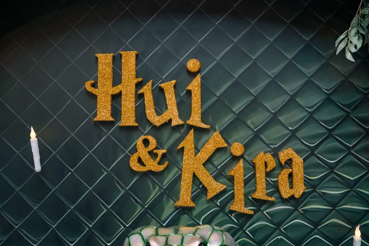 暗綠菱格背景，金色Hui & Kira名字，燭光與綠葉裝飾婚禮。