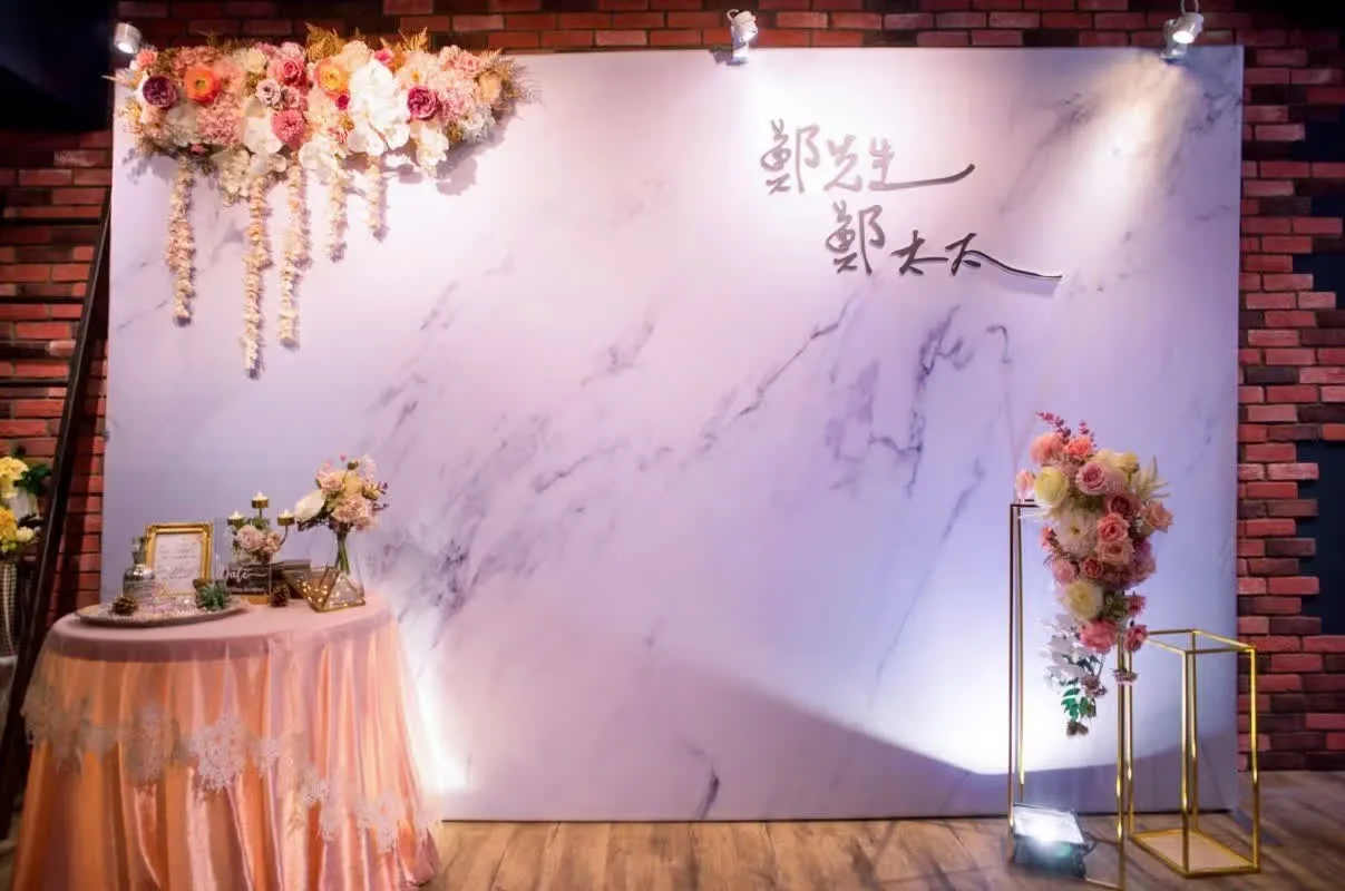 在幽靜的戶外森林場地中，圓形木質拱門點綴著粉白相間的繁茂花簇，搭配大地色系的佈置營造出浪漫且自然的唯美氛圍。