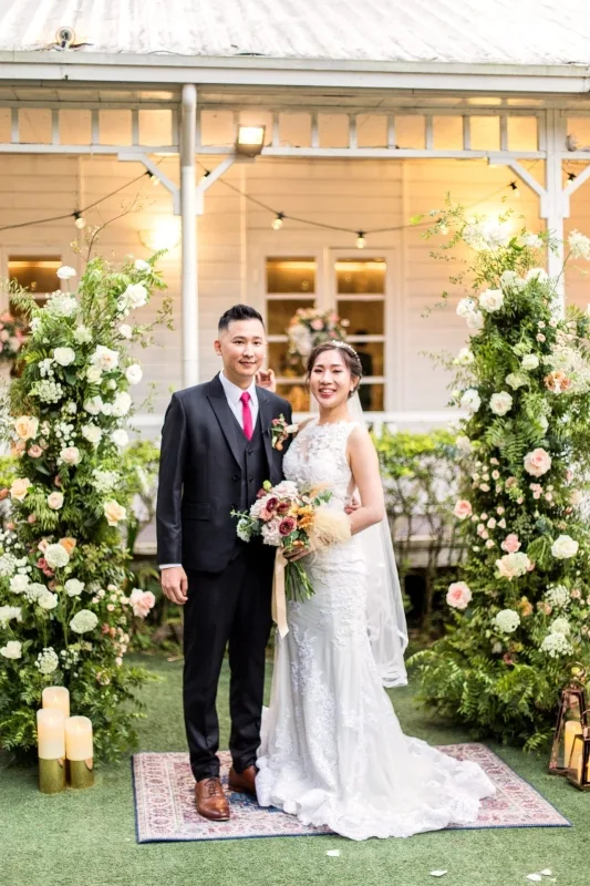 這場戶外草坪婚禮以圓形粉白花藝拱門與純白走道為核心佈置,色調清新柔美,在自然綠意簇擁下呈現出浪漫唯美且聖潔優雅的儀式氛圍。