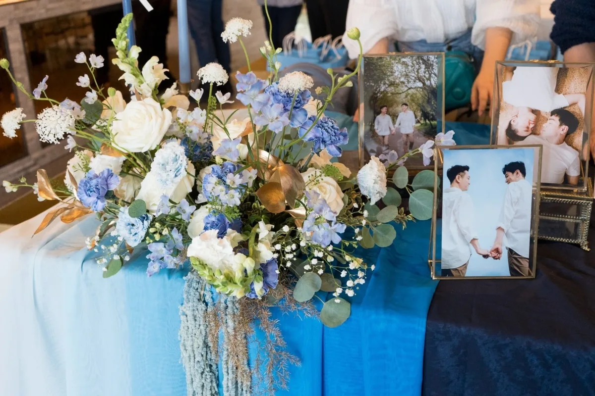 藍白色調花藝裝飾，搭配同性伴侶婚紗照，營造浪漫溫馨婚禮氛圍。