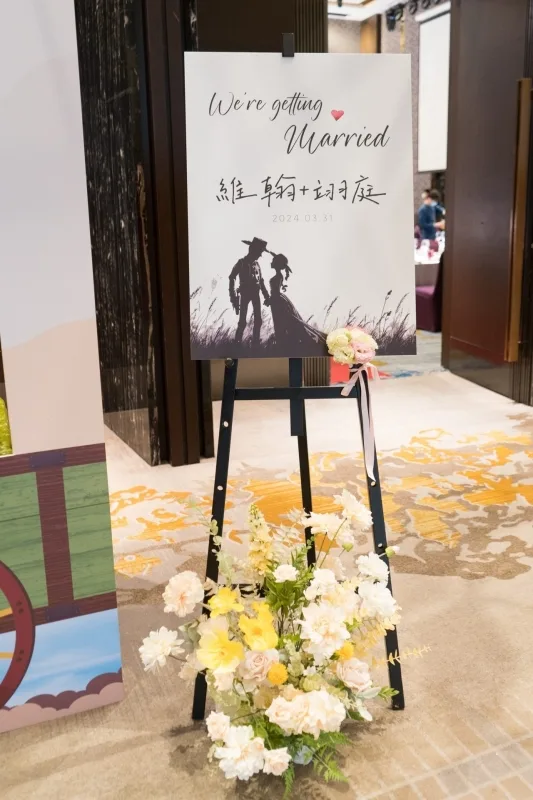 婚禮迎賓牌，柔和花卉裝飾，新人剪影，溫馨浪漫。