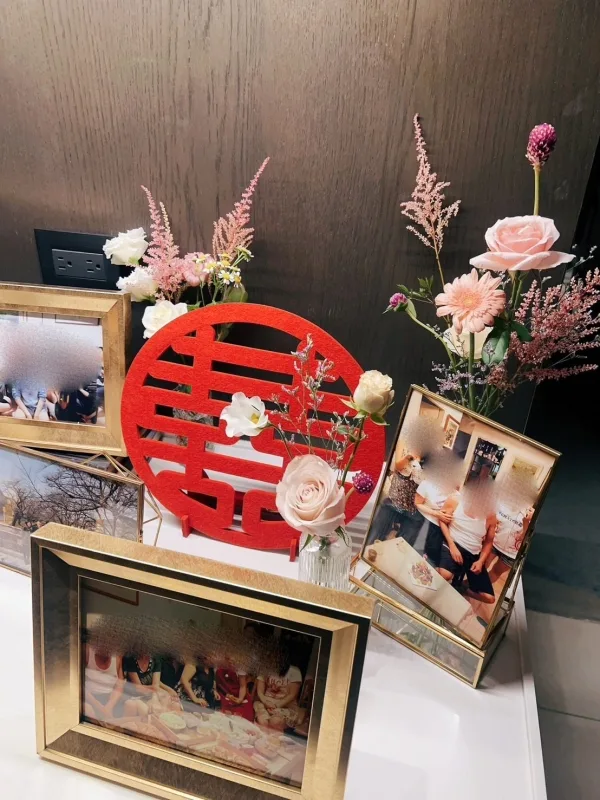 金色相框婚照、紅色雙喜字及粉嫩花藝，營造溫馨喜慶婚禮氛圍。