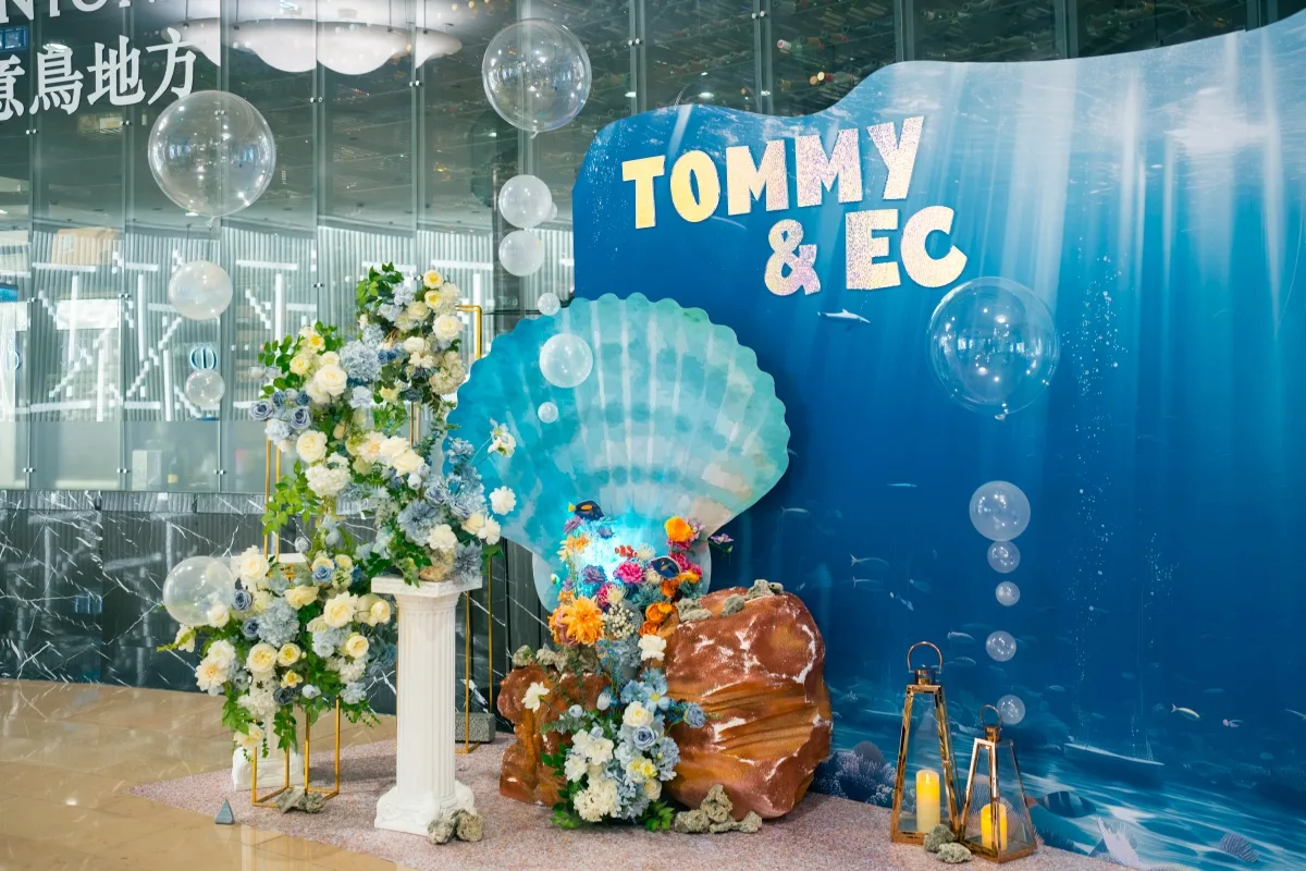 藍色海底主題婚禮佈景,有花藝、貝殼、燈籠及新人名字「TOMMY & EC」。