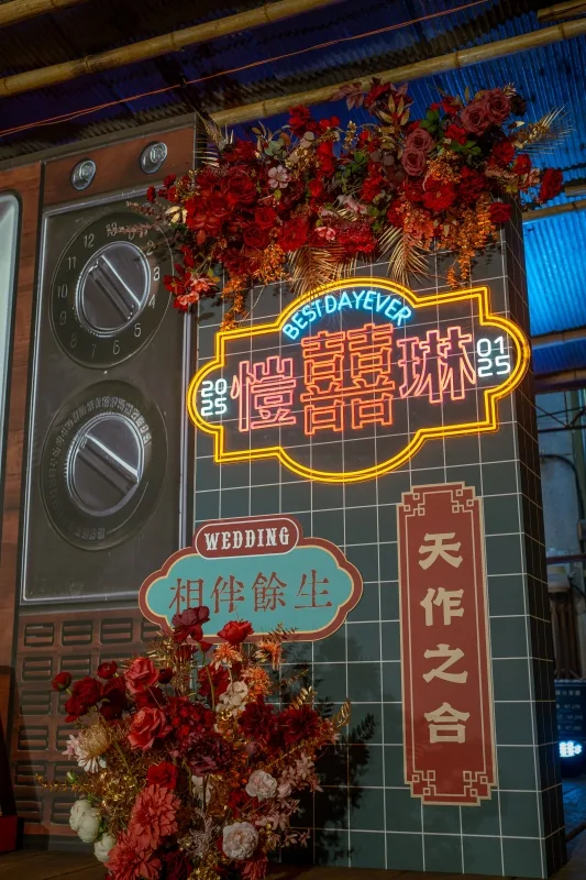 復古風婚禮佈置，霓虹燈、紅花、復古家電與瓷磚牆，喜慶而浪漫。