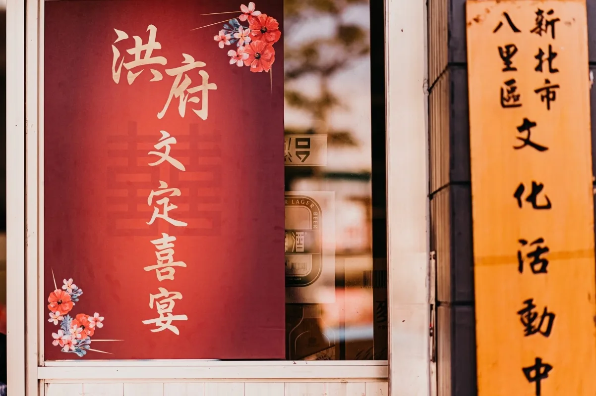 紅色喜慶招牌，金字「洪府文定喜宴」搭配花卉，洋溢傳統婚禮氣氛。