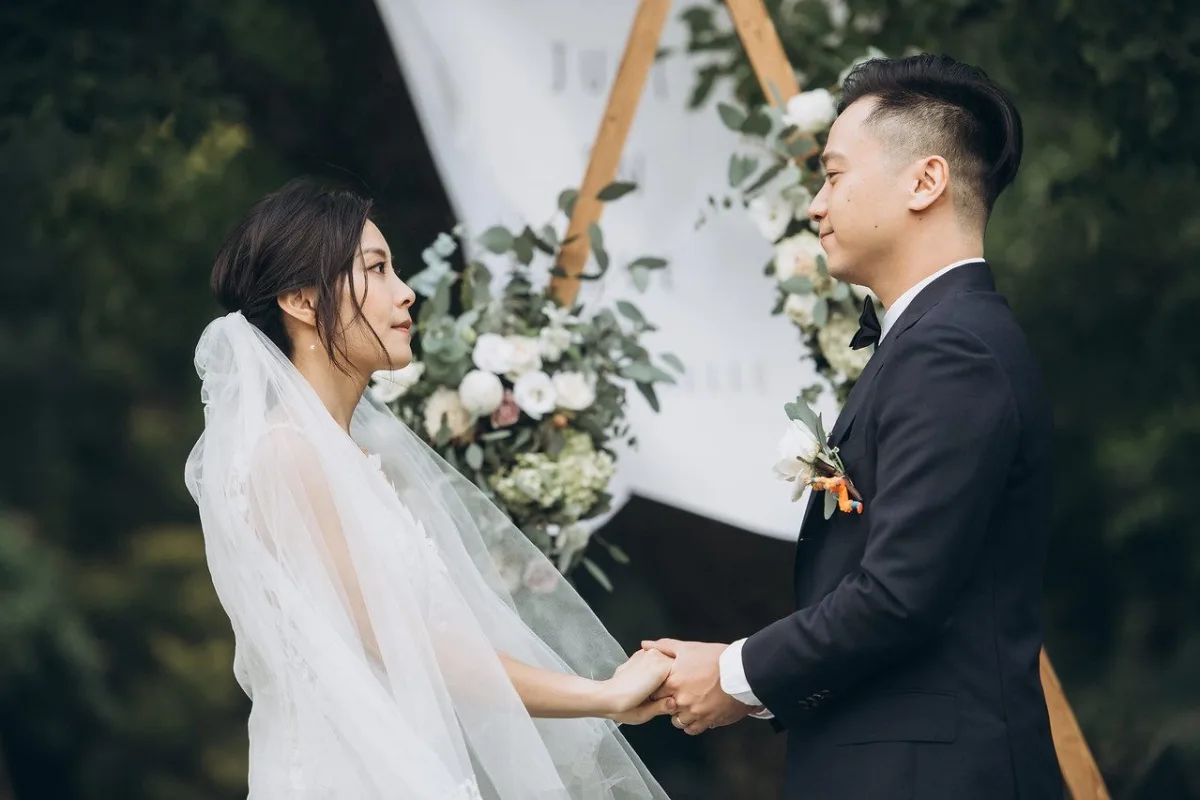這處戶外草坪婚禮場地以圓形藍白色系花卉拱門為中心,結合優雅的純白座椅與周圍清新綠意,展現出寧靜且充滿浪漫氣息的神聖儀式氛圍。